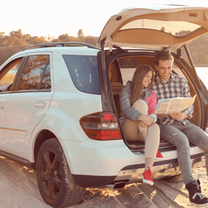 Young Couple Sitting in Car Trunk